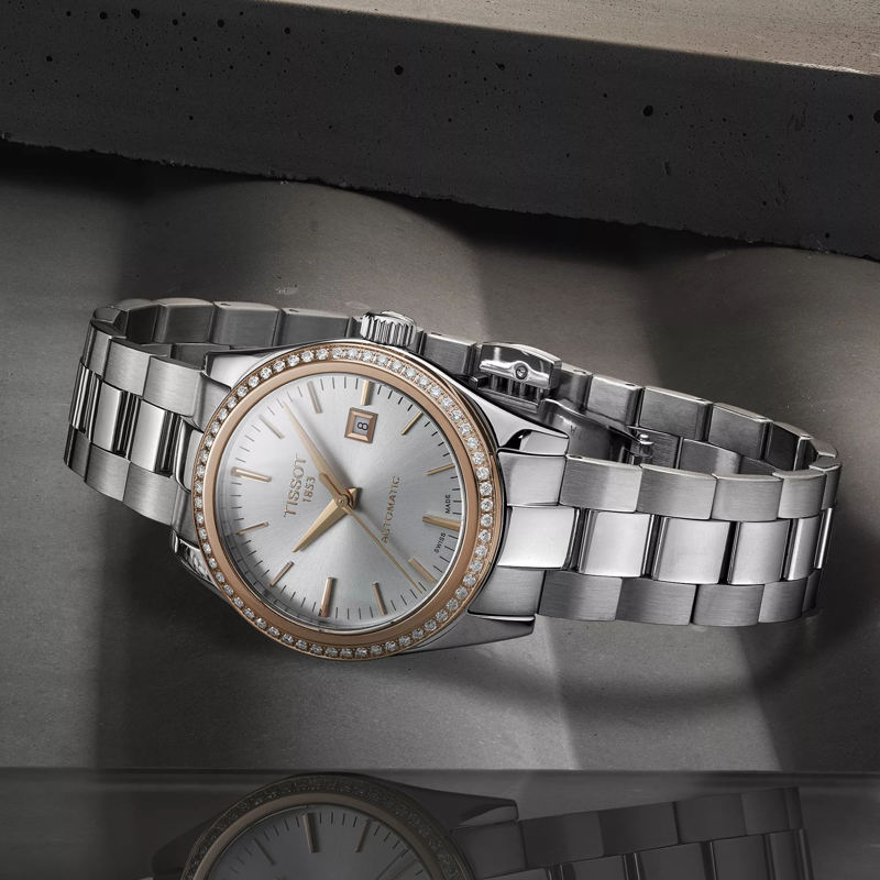 Tissot T-My Lady Automatic 18K Gold bezel watch on a colored background
