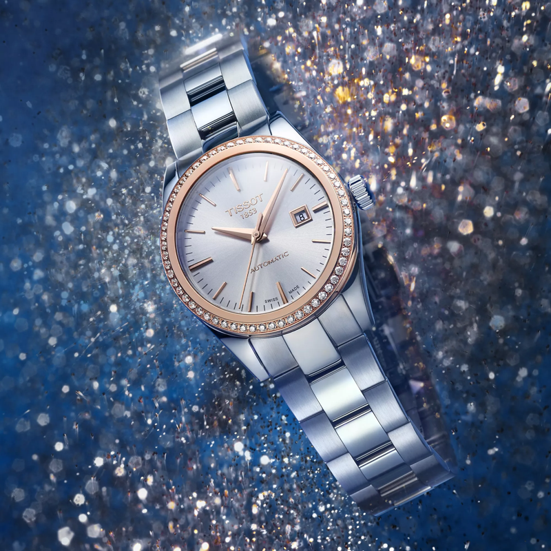 Tissot T-My Lady Automatic 18K Gold bezel watch on a colored background
